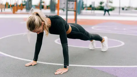 Mujer practicando un ejercicio isométrico: una flexión Mujer practicando un ejercicio isométrico: una flexión