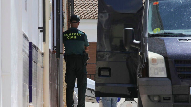 La Policía Judicial procede a la retirada de los cadáveres en un furgón funerario, del domicilio de Zafarraya (Granada) 