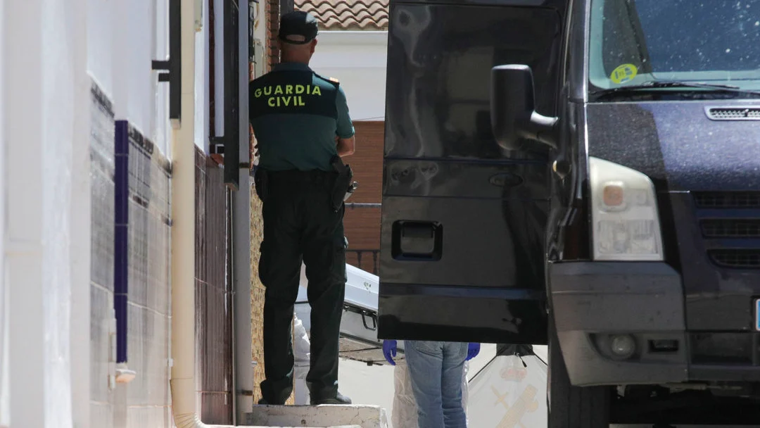 La Policía Judicial procede a la retirada de los cadáveres en un furgón funerario, del domicilio de Zafarraya (Granada) 