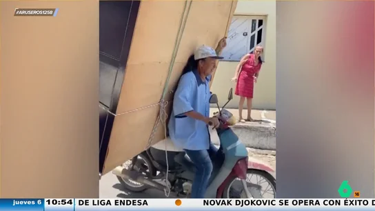Un hombre aprovecha para hacer la mudanza de su casa trasladando el armarro a modo mochila y en su moto Un hombre aprovecha para hacer la mudanza de su casa trasladando el armarro a modo mochila y en su moto