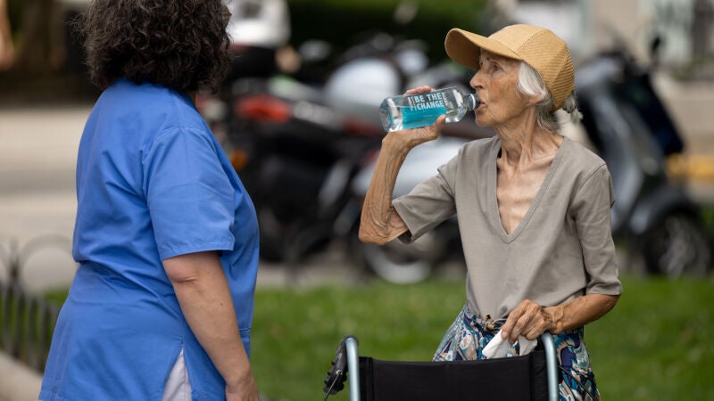 Una mujer bebe agua en plena ola de calor en Madrid.