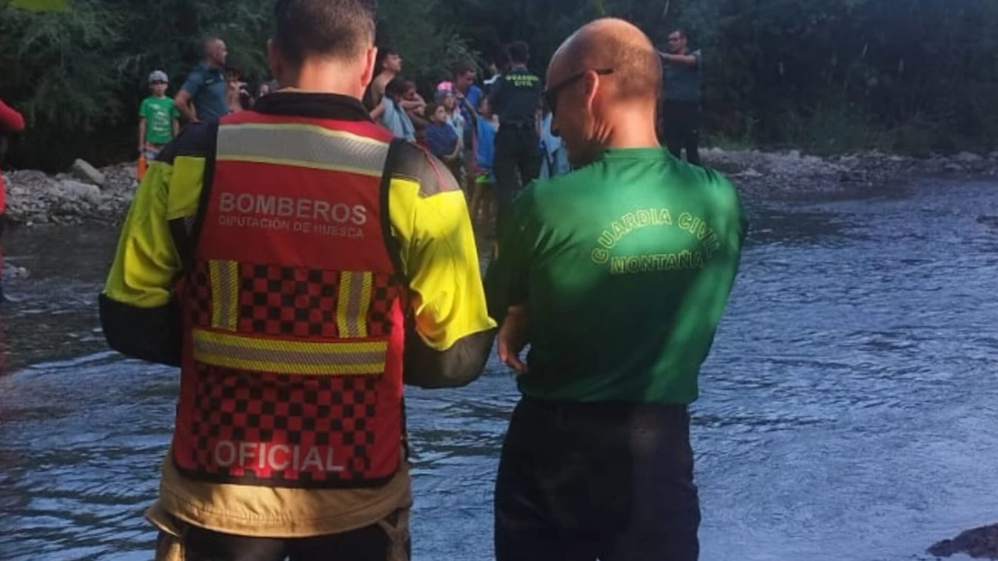 Rescatados ilesos 23 menores y dos monitores de campamento tras una crecida del Gállego en Biescas (Huesca) Dos bomberos de la Diputación Provincial de Huesca vigilan el lugar de los hechos.