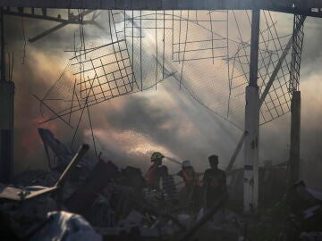 Palestinos inspeccionan los escombros de un edificio destruido tras un ataque aéreo israelí en el barrio de Al-Zawaida, en el centro de la Franja de Gaza, el 19 de julio de 2024. 