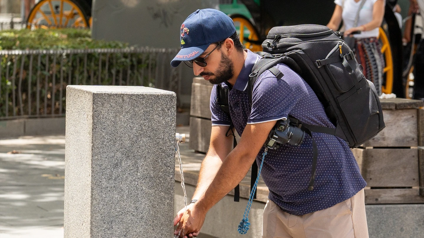 Una persona se echa agua en las manos para combatir el calor Una persona se echa agua en las manos para combatir el calor