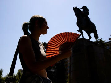 Una persona se abanica junto al caballo de Espartero en el Paseo del Espolón de Logroño
