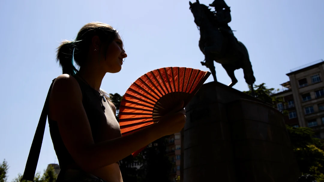 Una persona se abanica junto al caballo de Espartero en el Paseo del Espolón de Logroño