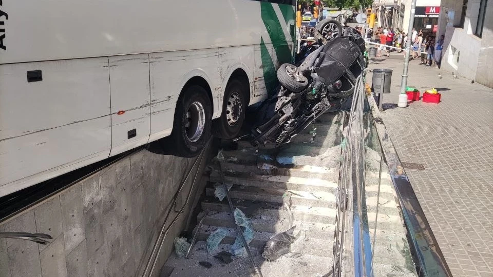 El autocar, junto al coche arrollado en la boca de metro de Carmel