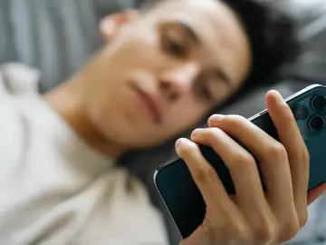 Un chico enganchado al móvil Un chico enganchado al móvil