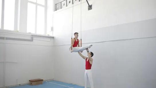 Dos deportistas aparecene entrenando anillas. Dos deportistas aparecene entrenando anillas.