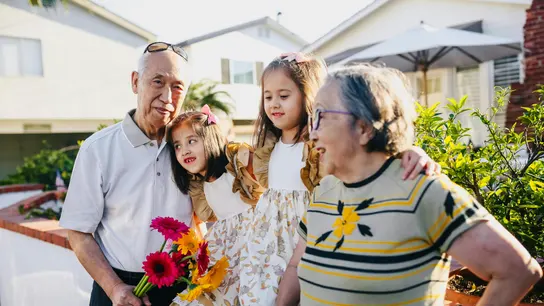 ¿Por qué el Día de los Abuelos se celebra el 26 de julio? Un abuelo y una abuela junto a sus dos nietas en el Día de los Abuelos.