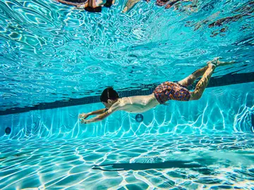 Niño bañándose en la piscina Niño bañándose en la piscina