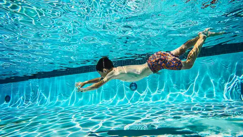 Niño bañándose en la piscina Niño bañándose en la piscina