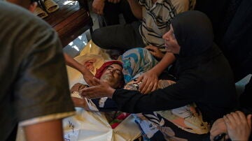 Palestinos lloran ante los cuerpos de sus familiares después de un bombardeo israelí al este del campamento de Jan Yunis. 