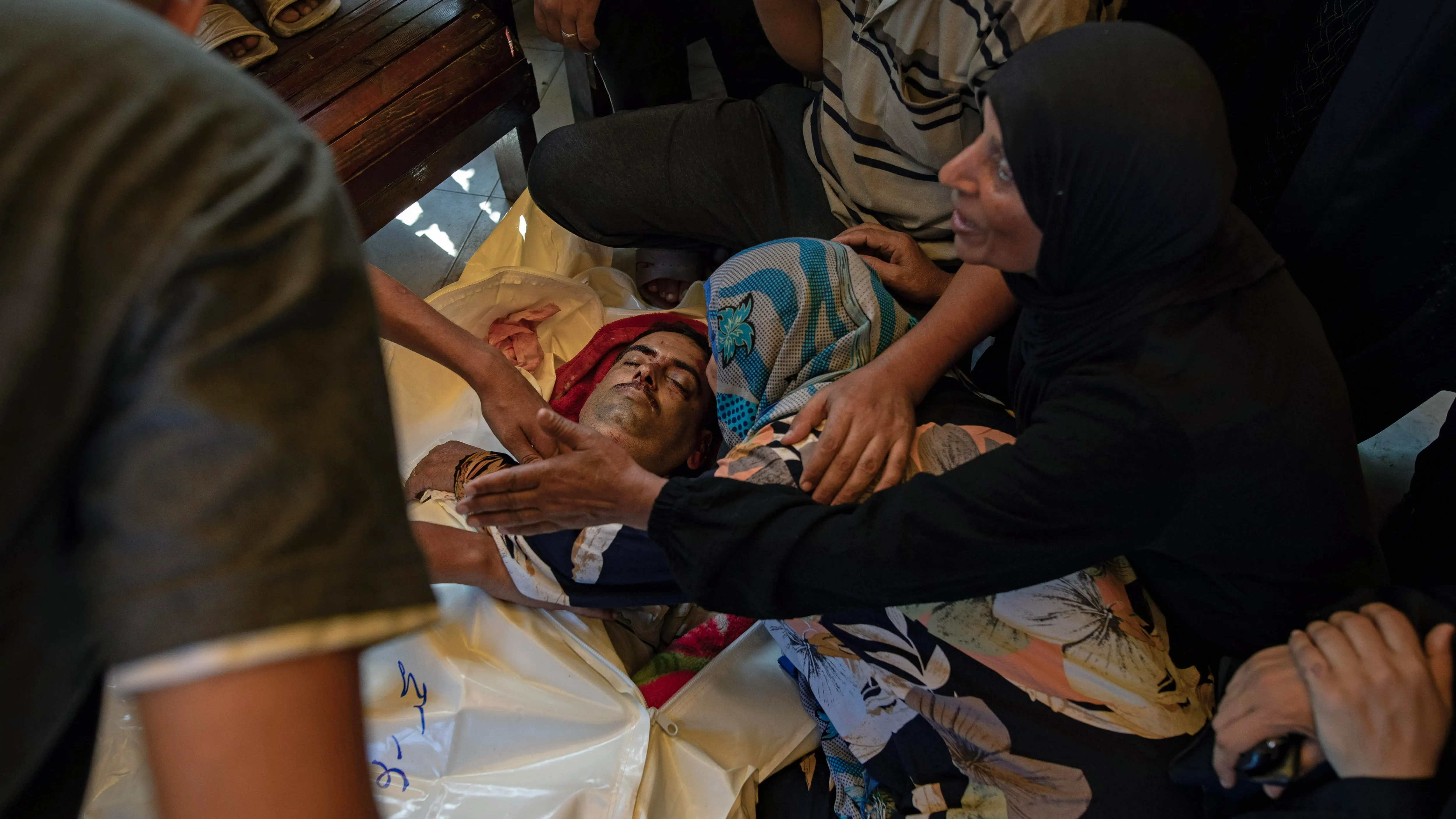 Palestinos lloran ante los cuerpos de sus familiares después de un bombardeo israelí al este del campamento de Jan Yunis. 