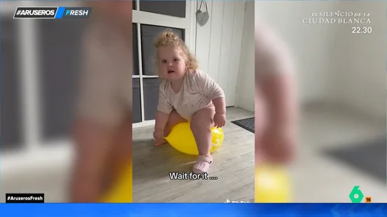 El divertido susto de una niña al pincharse el globo sobre el que está saltando El divertido susto de una niña al pincharse el globo sobre el que está saltando