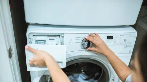 Imagen de archivo de una persona poniendo una lavadora Imagen de archivo de una persona poniendo una lavadora