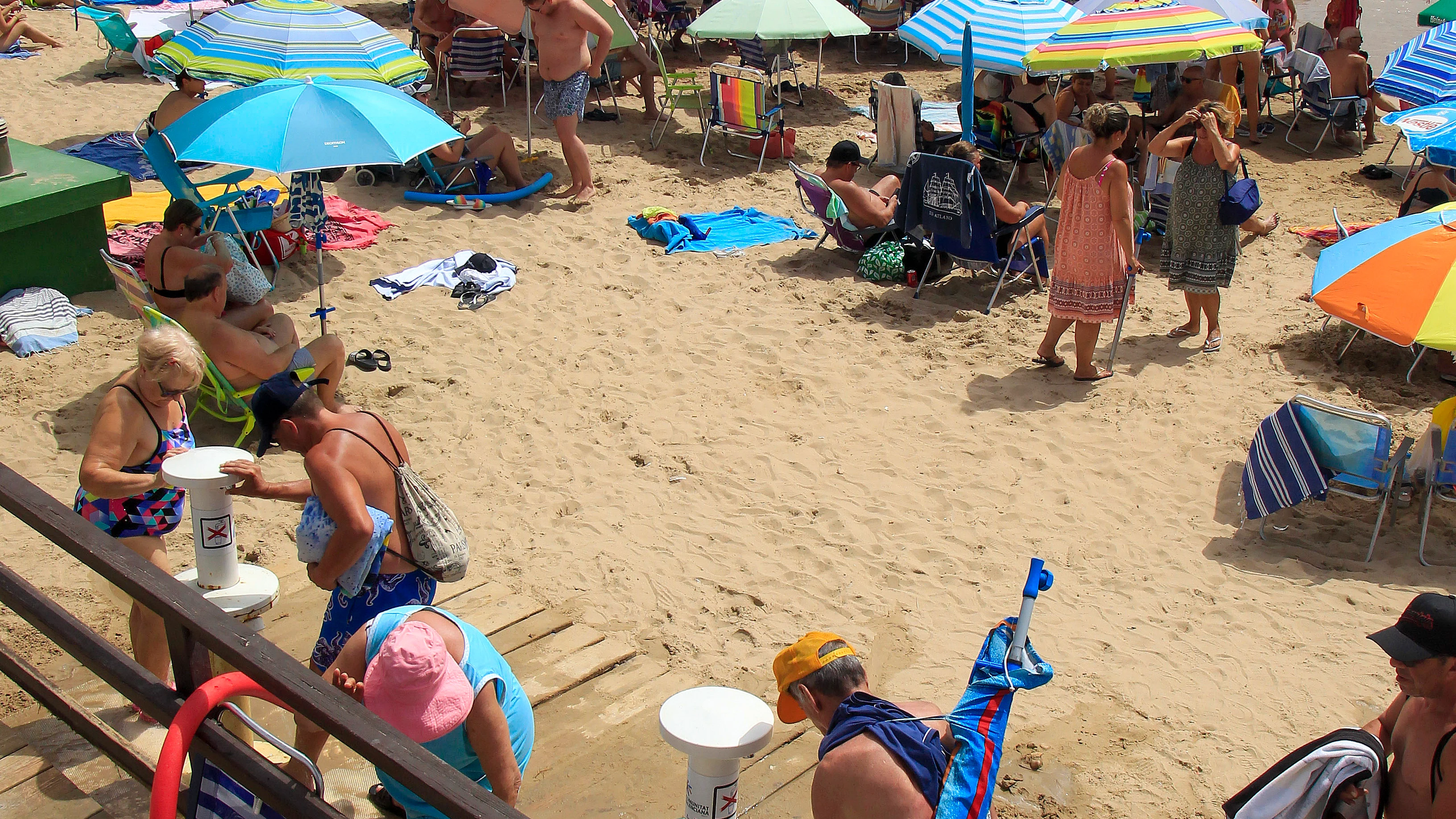 Un gran número de personas disfrutan del buen tiempo en la playa de El Cura de Torrevieja. EFE/Morell