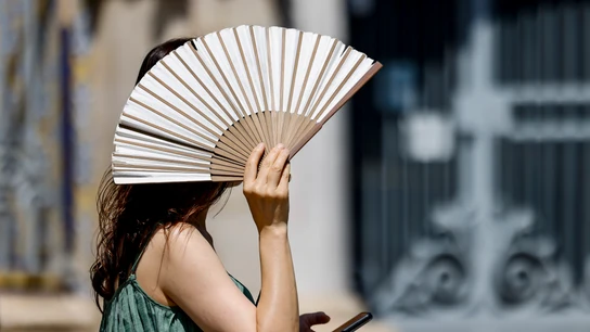 Una persona se protege del Sol con un abanico Una persona se protege del Sol con un abanico