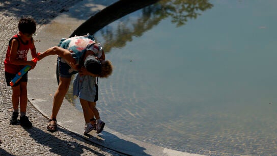 Una familia juega al lado de una fuente este martes en el parque de El Retiro en Madrid