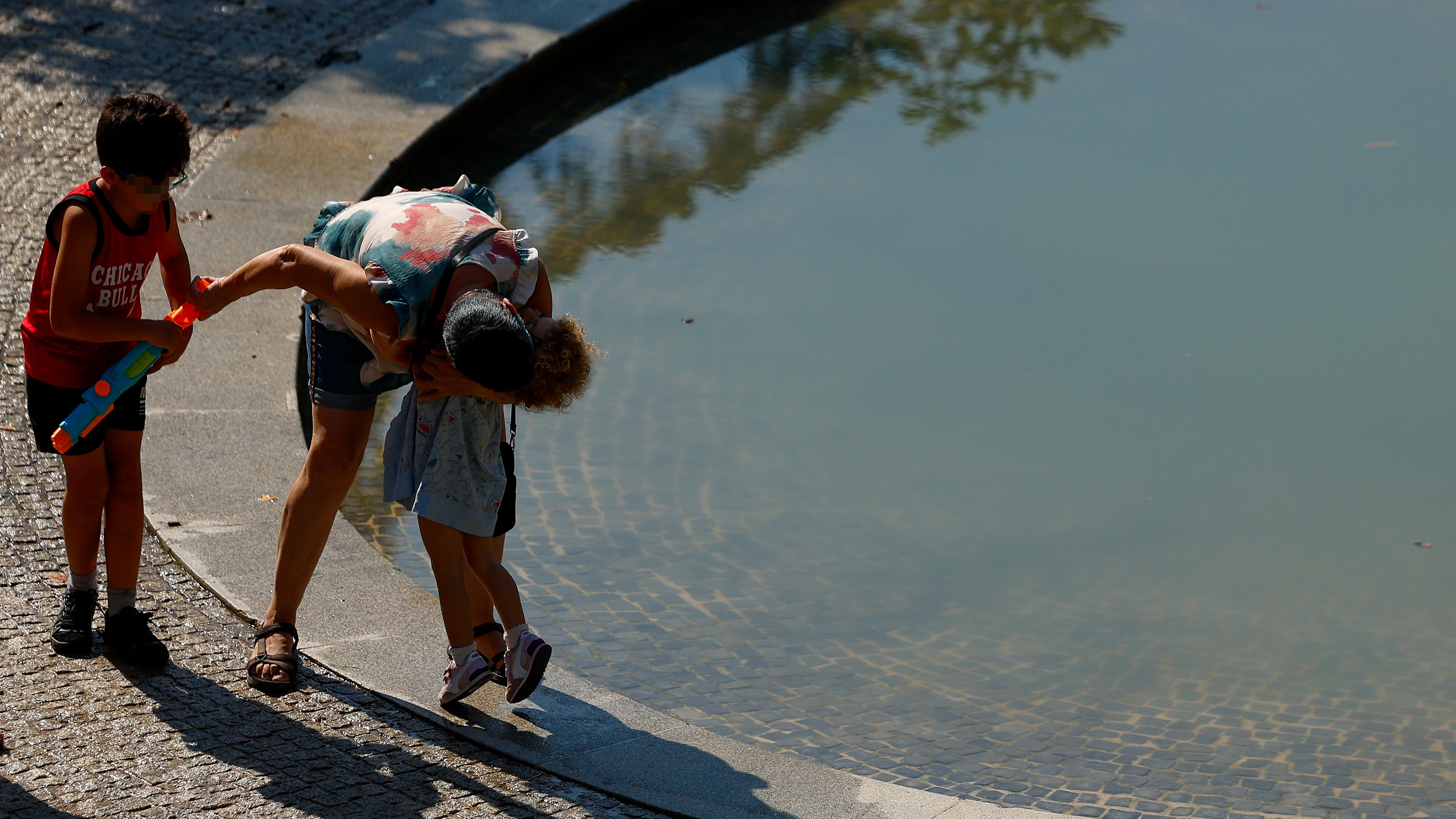 Una familia juega al lado de una fuente este martes en el parque de El Retiro en Madrid