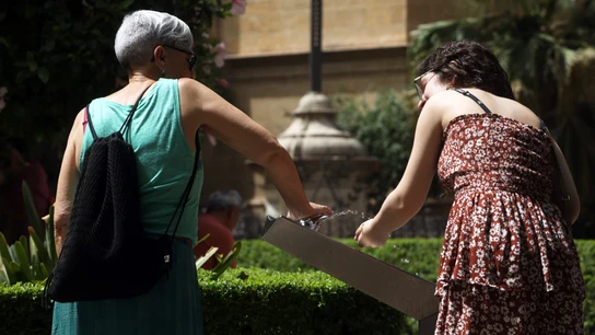 Dos mujeres recoge agua de una fuente para combatir la ola de calor que estos días azota la capital a 19 de julio e 2023 en Málaga, Andalucía. Dos mujeres recoge agua de una fuente para combatir la ola de calor que estos días azota la capital a 19 de julio e 2023 en Málaga, Andalucía.