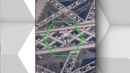 Hombre escalando la Torre Eiffel Hombre escalando la Torre Eiffel