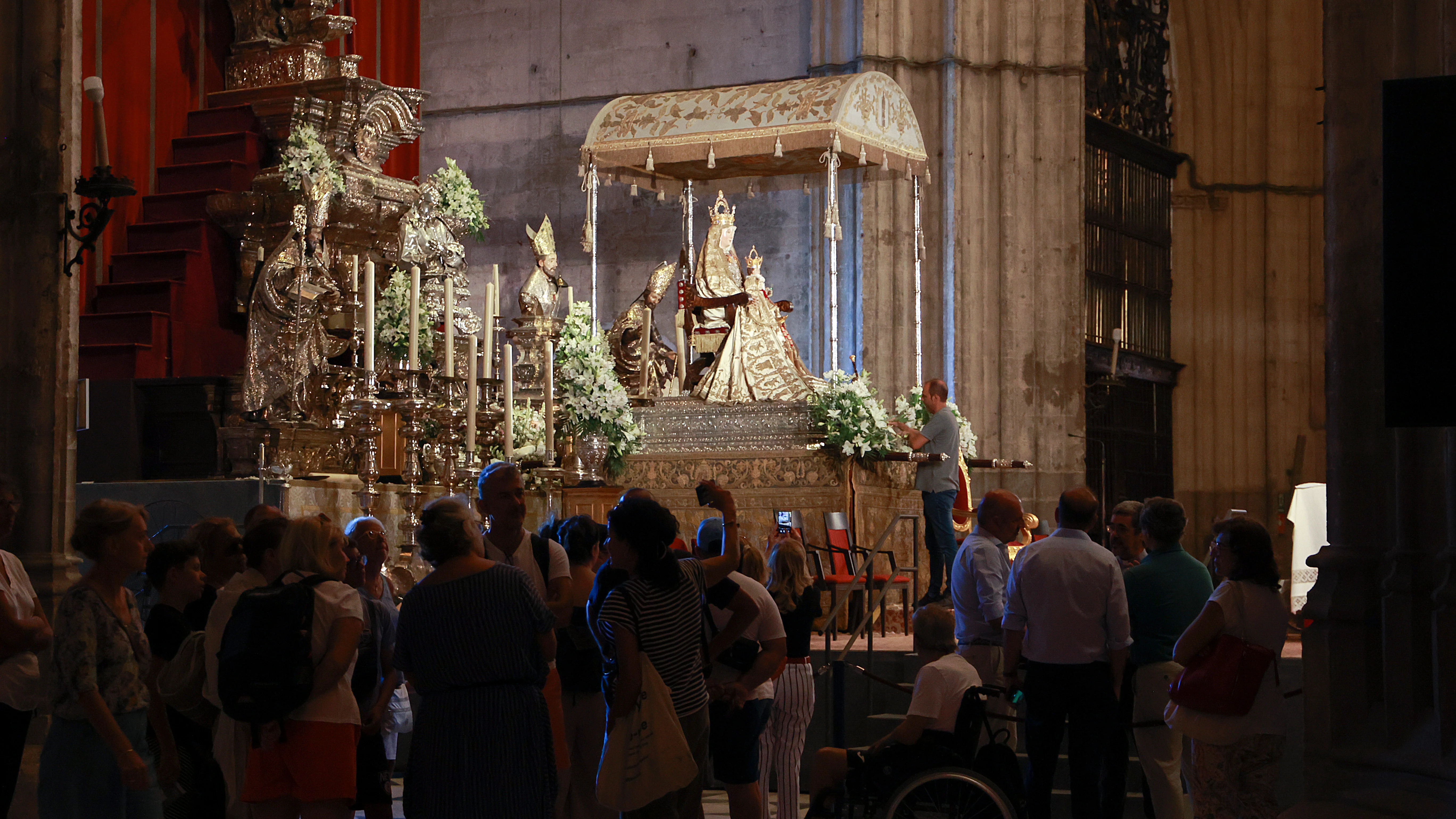 Fieles y turistas visitan a la Virgen de los Reyes en el altar del Jubileo en las vísperas de la Procesión, a 14 de agosto en Sevilla (Andalucía, España). 