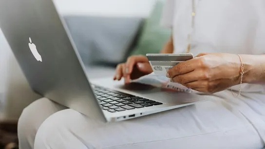Una persona hace una operación usando una tarjeta bancaria. Una persona hace una operación usando una tarjeta bancaria.