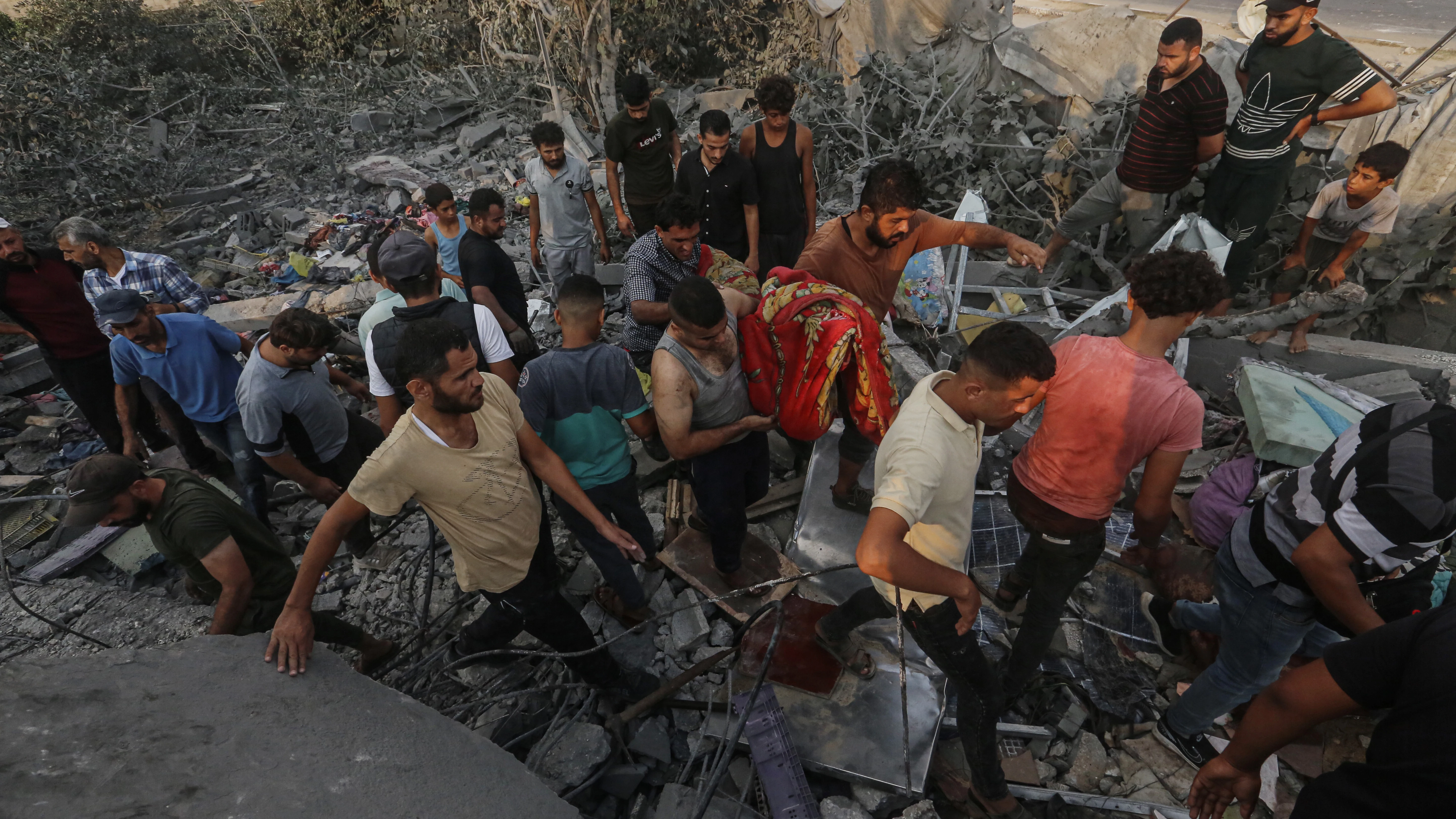 Los palestinos inspeccionan el lugar de un ataque aéreo israelí en una vivienda que alberga a personas desplazadas en Al Zawaida.