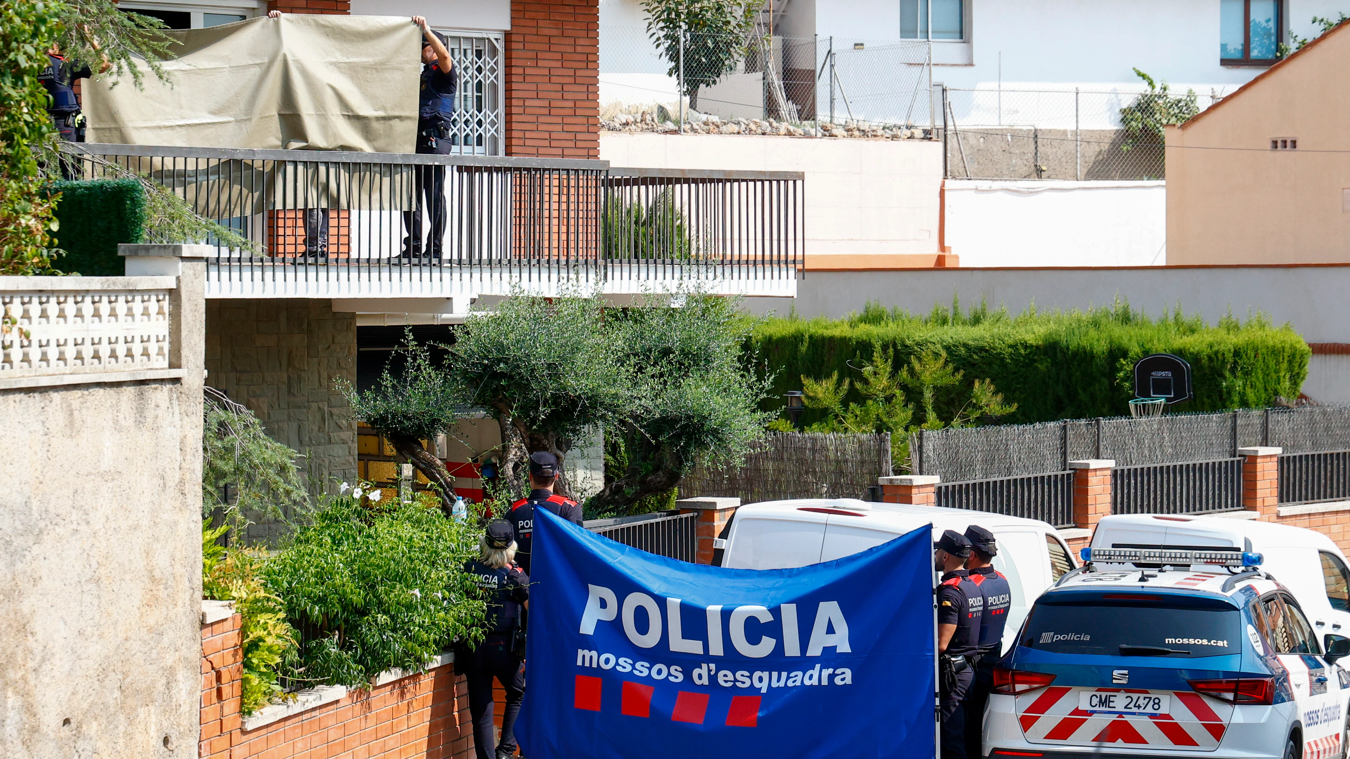 Agentes de Mossos trabajan en una casa donde han hallado sin vida a una mujer presuntamente asesinada por su pareja, un policía