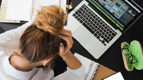 Mujer estresada ante un ordenador Mujer estresada ante un ordenador