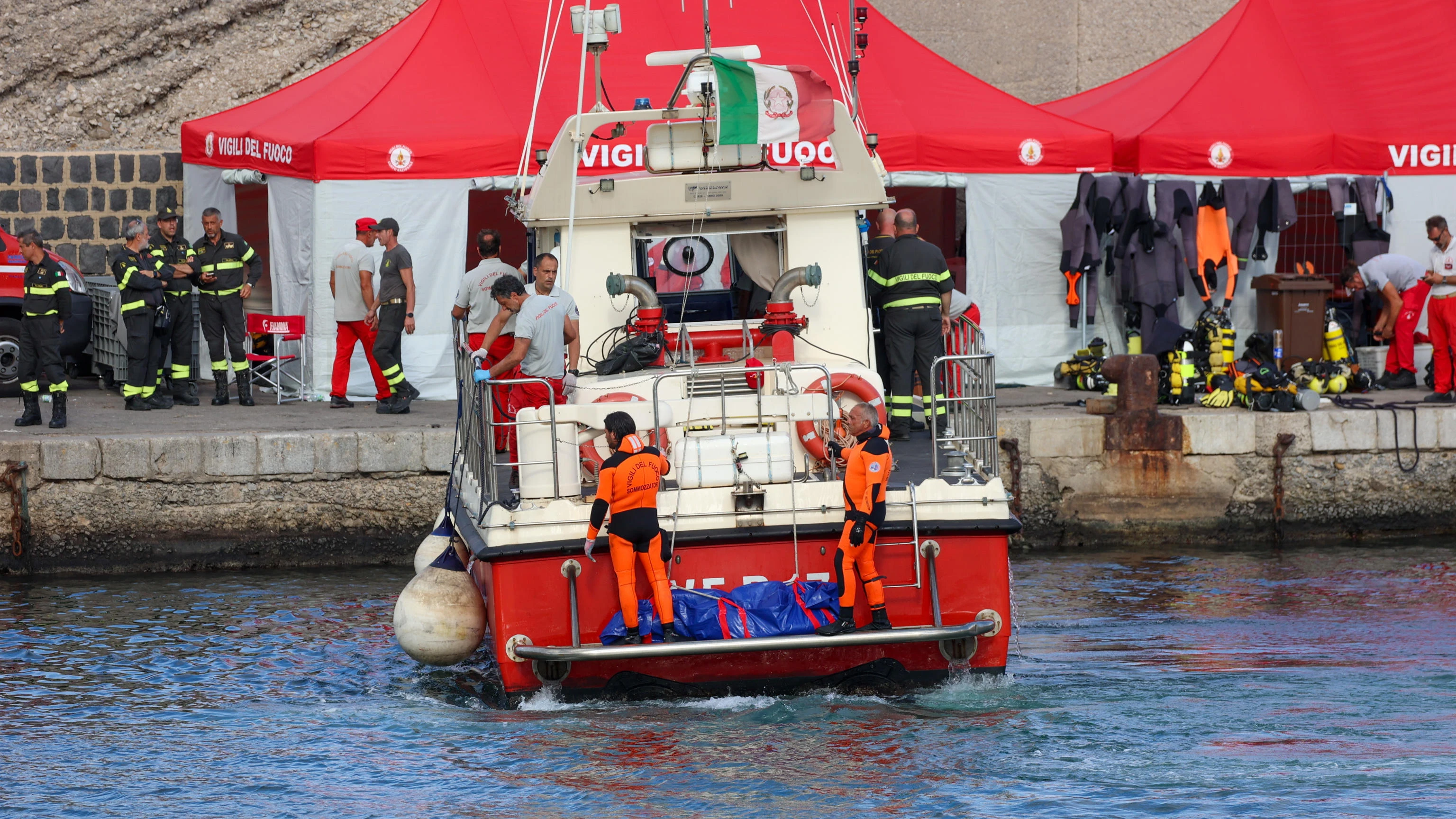 Un barco de rescate llega con el cuerpo de un pasajero del yate 'Bayesian' al puerto de Porticello, cerca de Palermo 