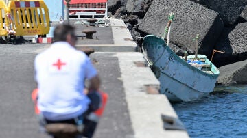 Un cayuco con 49 migrantes a bordo llega a la costa de El Hierro ante la mirada de un operario de Cruz Roja