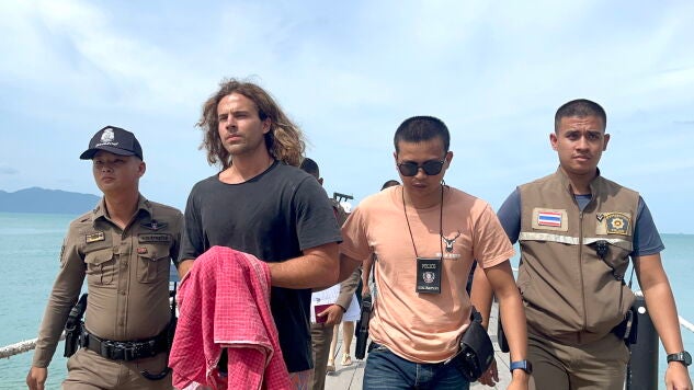 Fotograf&iacute;a de archivo de Daniel Sancho tras su detenci&oacute;n en Tailandia, escoltado por agentes de seguridad tailandeses cruzando un embarcadero.