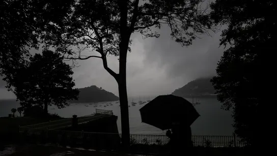 Un hombre se protege con el paraguas de una fuerte tormenta en el paseo de la Concha de San Sebastián. Un hombre se protege con el paraguas de una fuerte tormenta en el paseo de la Concha de San Sebastián.