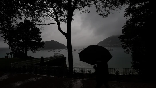 Un hombre se protege con el paraguas de una fuerte tormenta en el paseo de la Concha de San Sebastián. E Un hombre se protege con el paraguas de una fuerte tormenta en el paseo de la Concha de San Sebastián. E