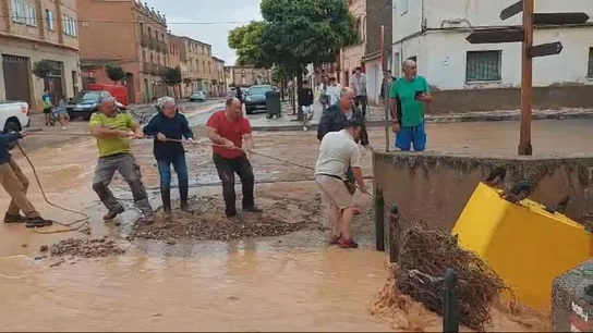 Varios vecinos de Cetina tratan de evitar que la corriente se lleve un contenedor, este viernes. Varios vecinos de Cetina tratan de evitar que la corriente se lleve un contenedor, este viernes.