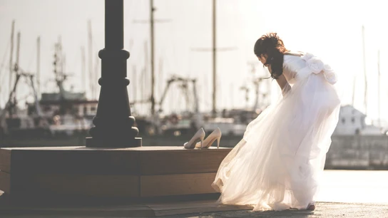 Una mujer vestida de novia sola se cambia de zapatos. Una mujer vestida de novia sola se cambia de zapatos.