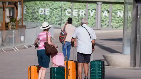 Dos señores mayores esperan con sus maletas en una calle de Madrid Dos señores mayores esperan con sus maletas en una calle de Madrid