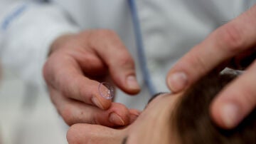 Un trabajadora de la óptica de Primera Opticos Fersan sujeta una lentilla, a 30 de mayo de 2024, en Alcalá de Henares, Madrid (España).