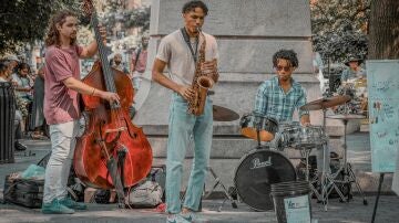 Tres músicos dan un concierto en la calle.