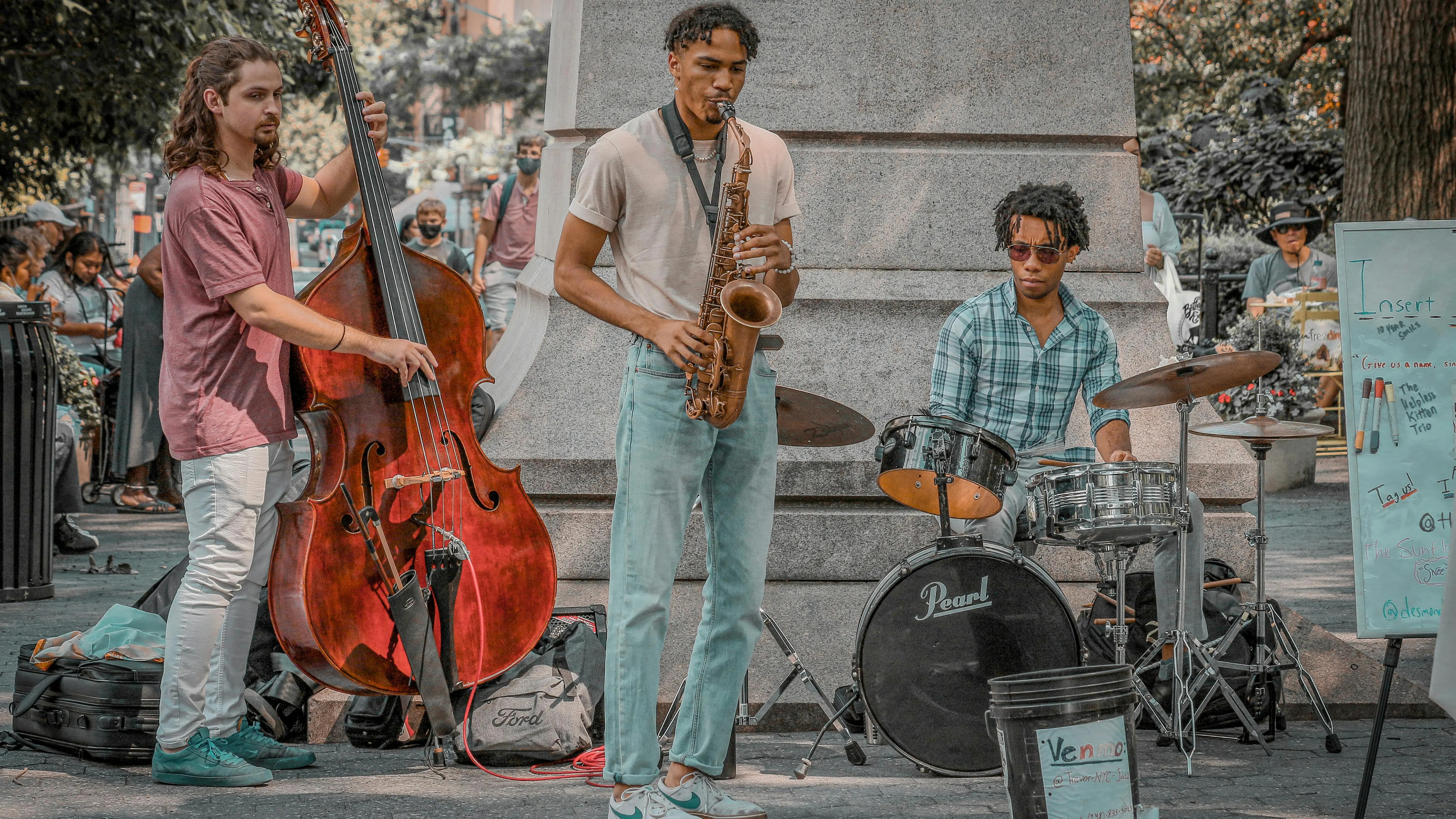 Tres músicos dan un concierto en la calle.