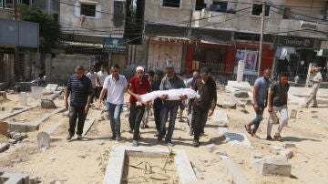 Varios palestinos cargan a una persona muerta tras un ataque israelí a la escuela de UNRWA en Nuseirat