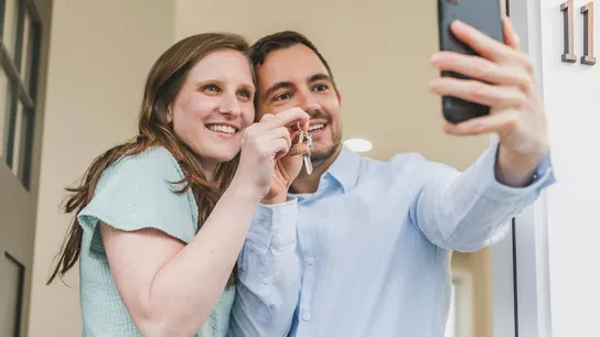 Una pareja se hace una foto con las llaves de su nueva casa. Una pareja se hace una foto con las llaves de su nueva casa.