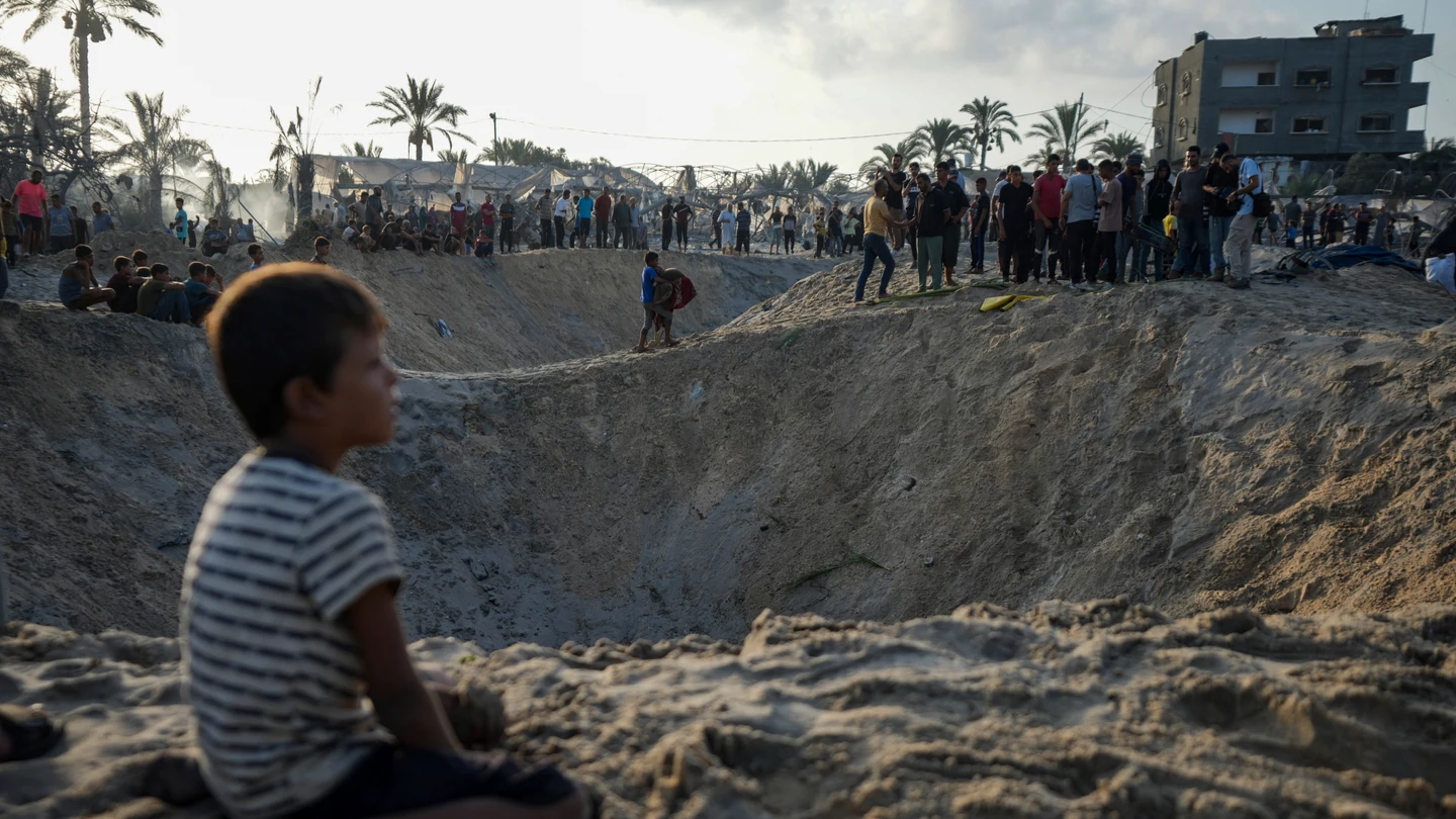 Palestinos observan la destrucción después de un ataque aéreo israelí contra un campo de refugiados lleno de palestinos desplazados por la guerra en Muwasi. Palestinos observan la destrucción después de un ataque aéreo israelí contra un campo de refugiados lleno de palestinos desplazados por la guerra en Muwasi.