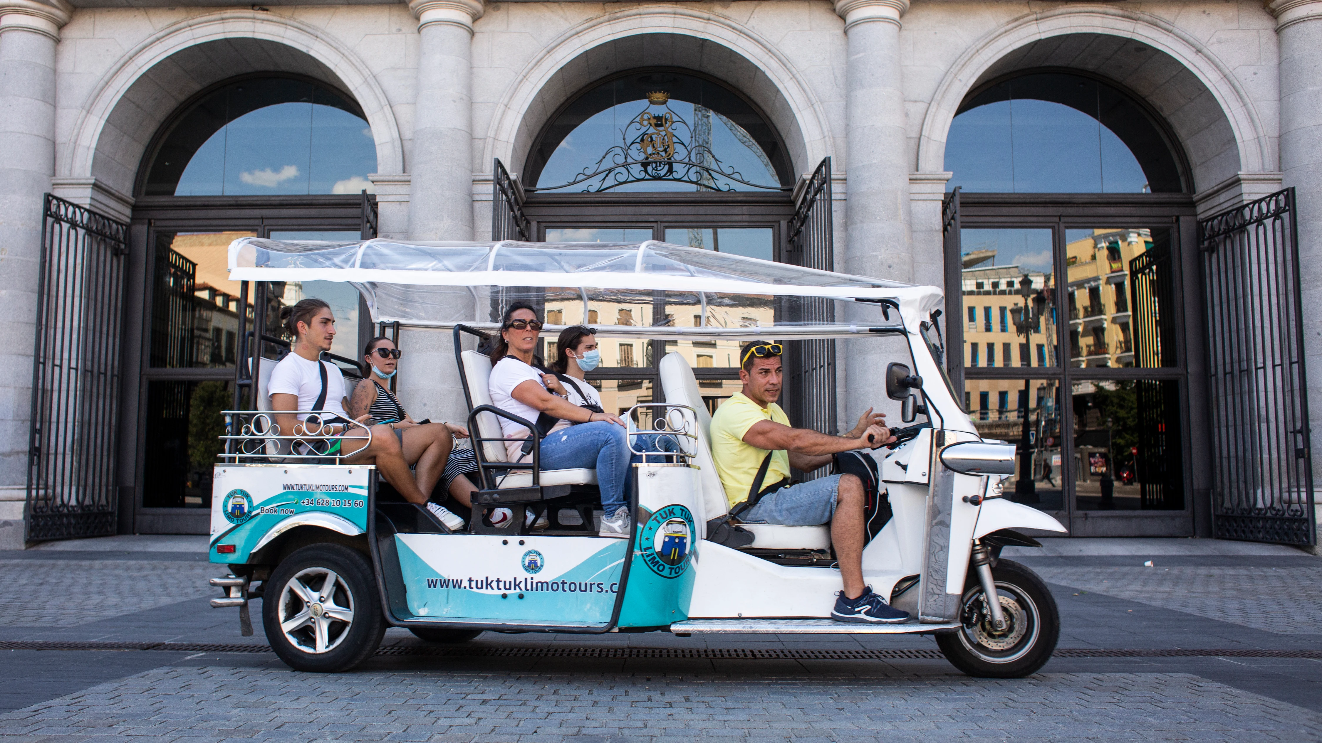 Un tuk tuk, en el que los ocupantes van, en su mayoría sin mascarilla, frente al Teatro Real, durante el primer día en el que no es obligado el uso de la mascarilla en exteriores desde el inicio de la pandemia, a 26 de junio de 2021, en Madrid (España). 