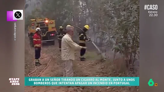 Un hombre arroja un cigarrillo al monte al mismo tiempo que los bomberos trabajan para extinguir un incendio Un hombre arroja un cigarrillo al monte al mismo tiempo que los bomberos trabajan para extinguir un incendio