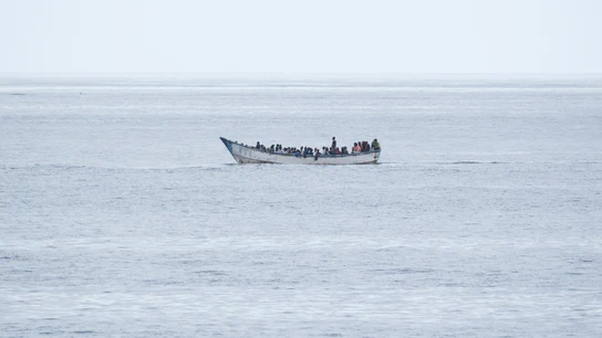 Foto de archivo de un cayuco con decenas de personas a bordo. Foto de archivo de un cayuco con decenas de personas a bordo.