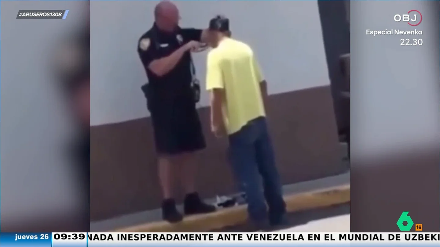 Un policía ayuda a afeitarse a una persona sintecho para que vaya a la entrevista de trabajo como un pincel Un policía ayuda a afeitarse a una persona sintecho para que vaya a la entrevista de trabajo como un pincel