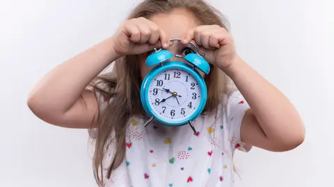 Niña sujetando un reloj Niña sujetando un reloj